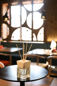 Close-up of sticks in glass bottle on table