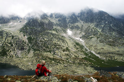 Woman looking at view while sitting on mountain