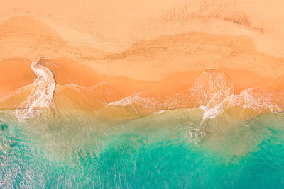 Aerial view of atlantic ocean coast with crystal clear turquoise water, waves rolling into the shore