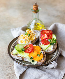 A variety of sandwiches with multigrain bread, cream cheese, vegetables and eggs. 