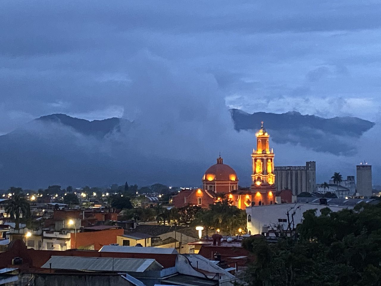 ILLUMINATED BUILDINGS BY CITY AGAINST SKY