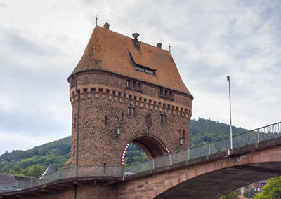 Low angle view of arch bridge against cloudy sky