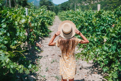 Rear view of woman standing by plants