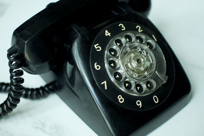 Close-up of black rotary phone on table