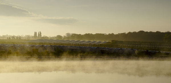 Scenic view of dam against sky at sunset