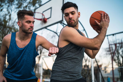 Close-up of men playing basketball outdoors