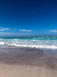 Scenic view of beach against blue sky