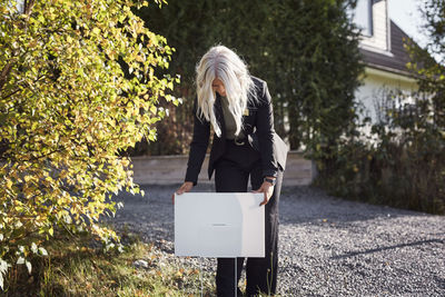 Female estate agent putting for sale sign