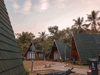 Low angle view of palm trees and building against sky