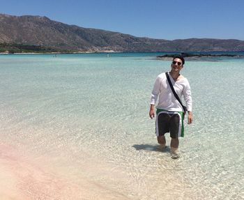 Full length of man standing on beach against sky