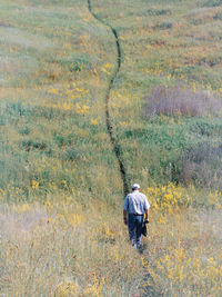 Rear view of man walking on field