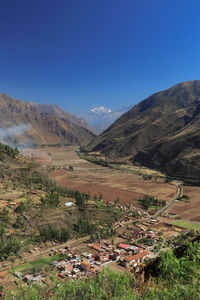 Scenic view of landscape and mountains against blue sky