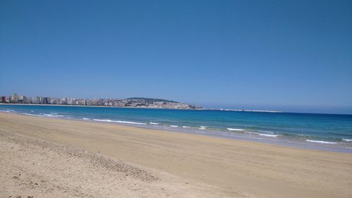 Scenic view of beach against clear blue sky