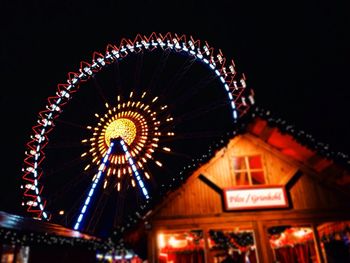 Low angle view of illuminated ferris wheel against sky at night