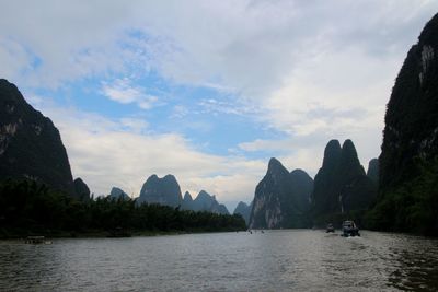 Scenic view of river and mountains against sky