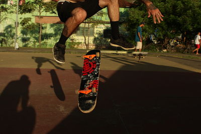 Low section of men jumping in park