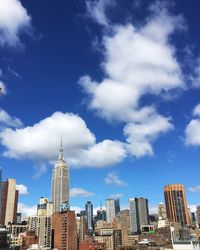 Low angle view of modern buildings against cloudy sky