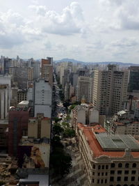 View of cityscape against cloudy sky