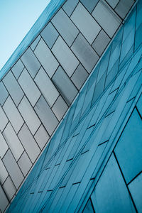 Low angle view of modern building against blue sky