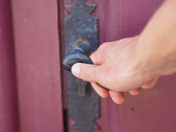 Cropped hand of man holding handle on door