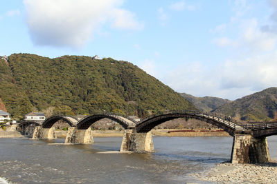 Arch bridge over river against sky