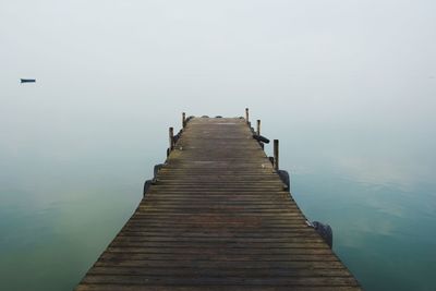 Wooden pier over sea against sky