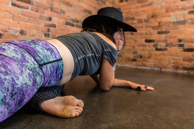 Full length of woman lying on wall