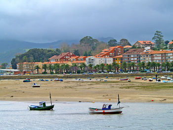 Scenic view of town by sea against sky