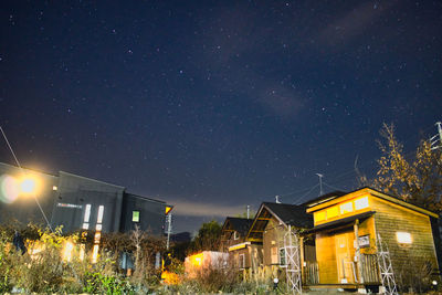 Low angle view of illuminated buildings against sky at night