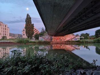 Bridge over river in city against sky