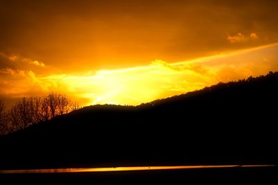 Scenic view of silhouette landscape against orange sky