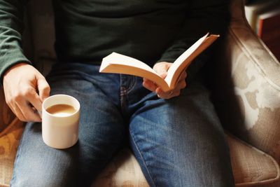 Midsection of man holding coffee cup