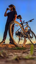 Low angle view of man riding bicycle against sky