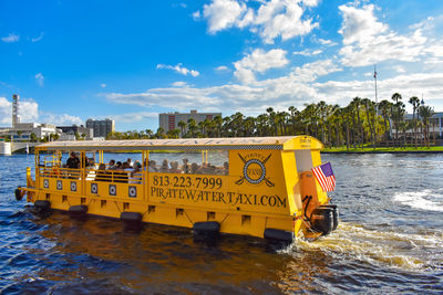 Information sign by river against sky