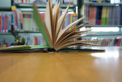 Close-up of open book on table at library