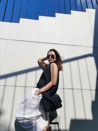 Young woman standing against wall