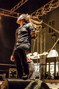 Low angle view of woman playing at music concert