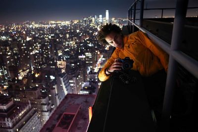 Woman standing in illuminated city at night