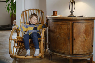 Child in rocking chair in vintage house. retro home for family. boy kid resting in armchair