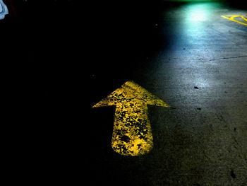 High angle view of yellow arrow sign on street