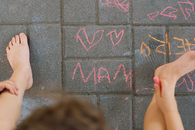 Cute boy draws the word mother with chalk. the boy loves his mother.