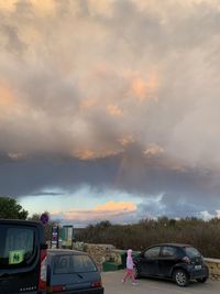 Cars on road against sky during sunset