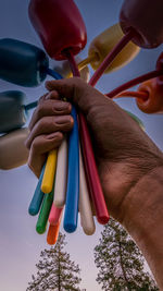 Cropped hand of woman holding colorful clothespins