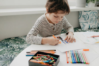 The boy draws with felt-tip pens. high quality photo