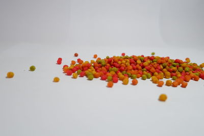 Close-up of orange berries on table against white background