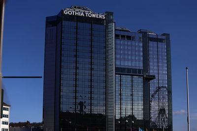 Low angle view of modern building against blue sky