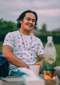 Portrait of smiling man sitting in yard