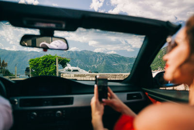 Woman using mobile phone in car