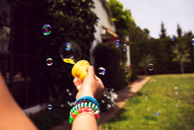 Full length of woman playing with bubbles