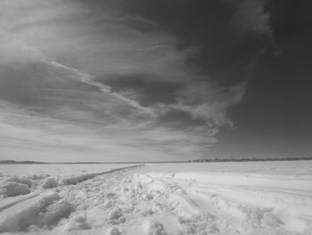 Snow covered land against sky